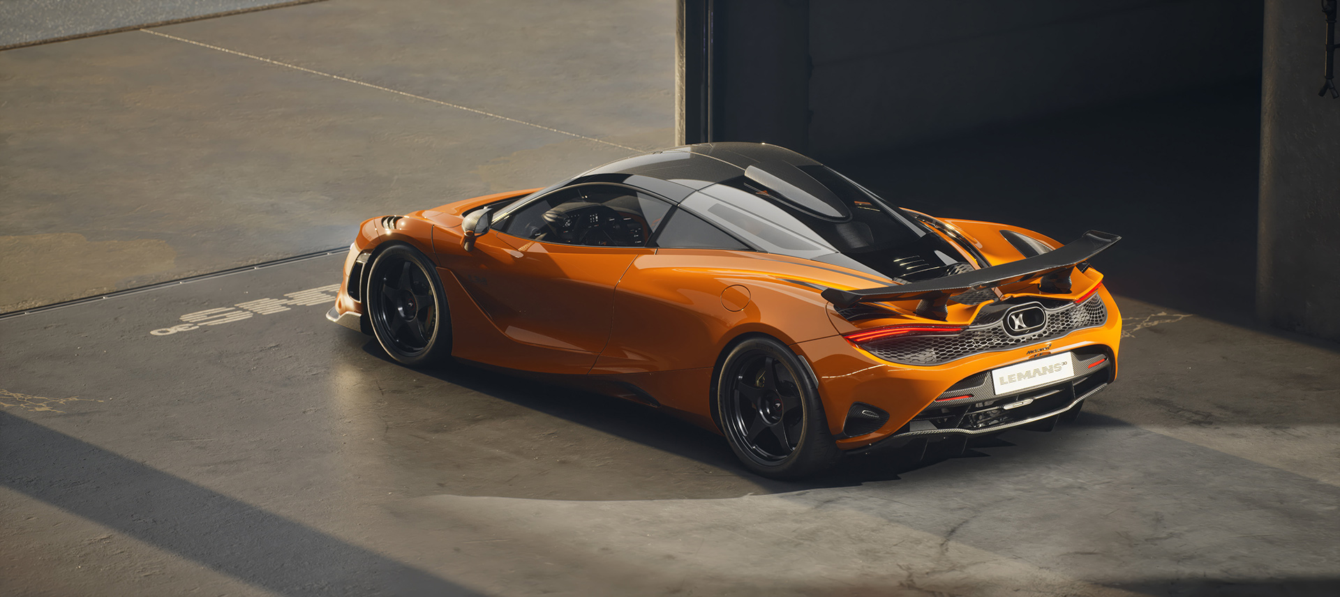 A rear-three-quarter view of an orange McLaren 750S Le Mans edition, highlighting the active rear spoiler and 'LE MANS' branding while parked in a garage.