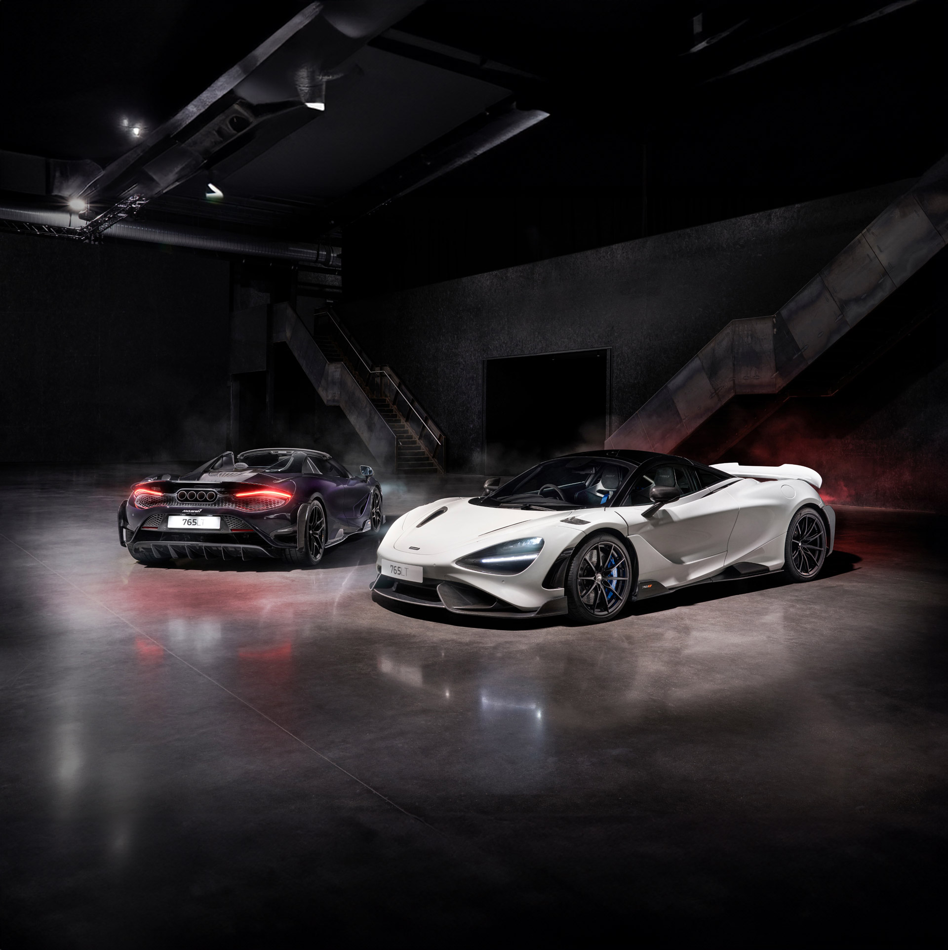 A dynamic shot of a purple McLaren 765LT and a white 765LT Spider, showcasing the modern Longtail's aggressive design.