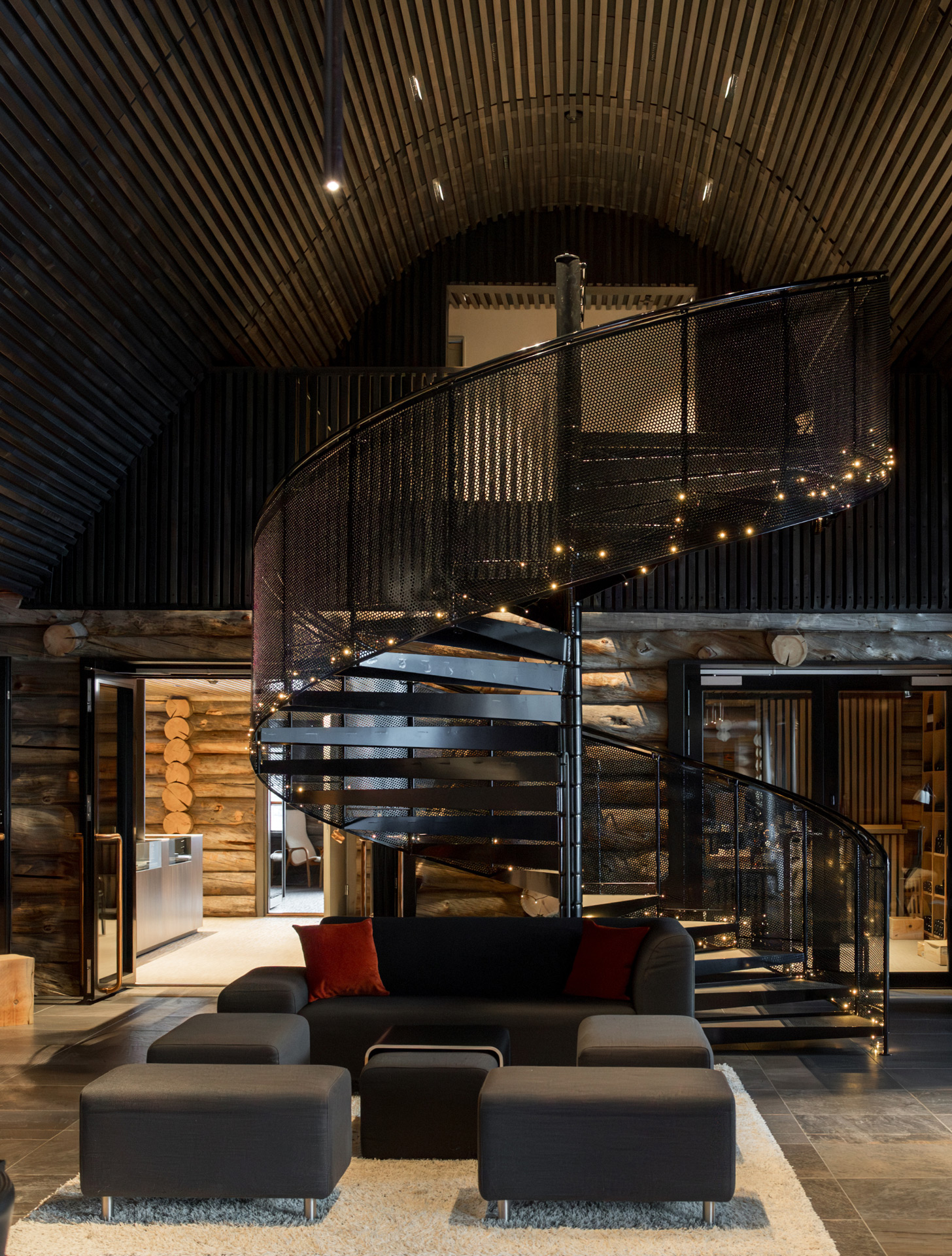 A modern black spiral staircase inside Javri Lodge, a central feature of the luxury accommodation.