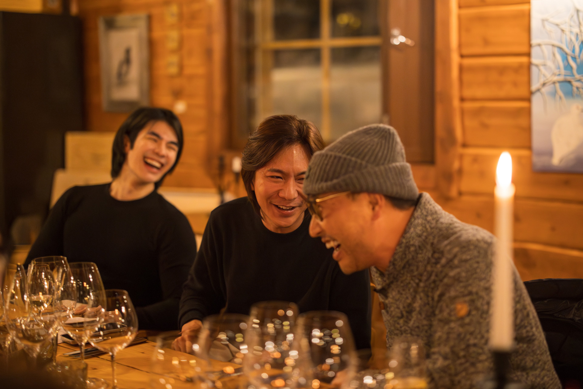 Guests at the McLaren Arctic Experience enjoying dinner and conversation at a table filled with wine glasses and candlelight.