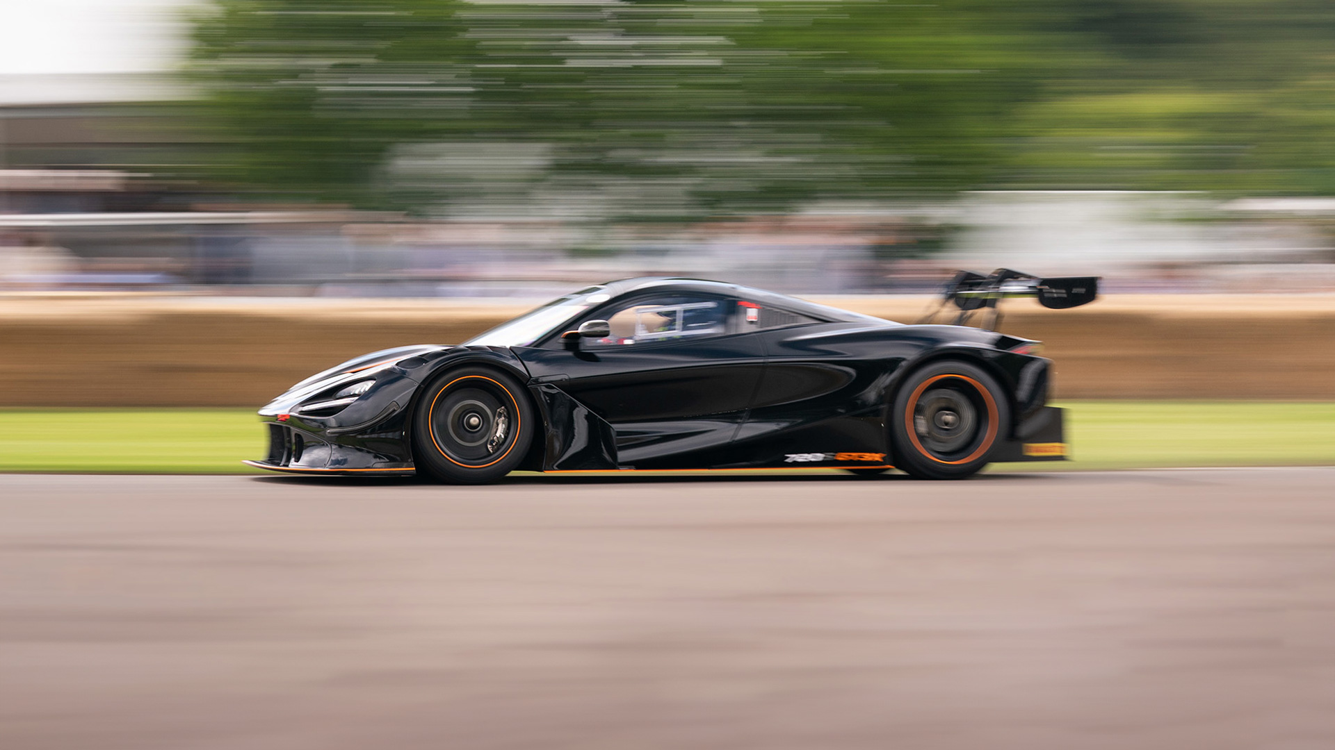 A fast moving McLaren car on a race track.