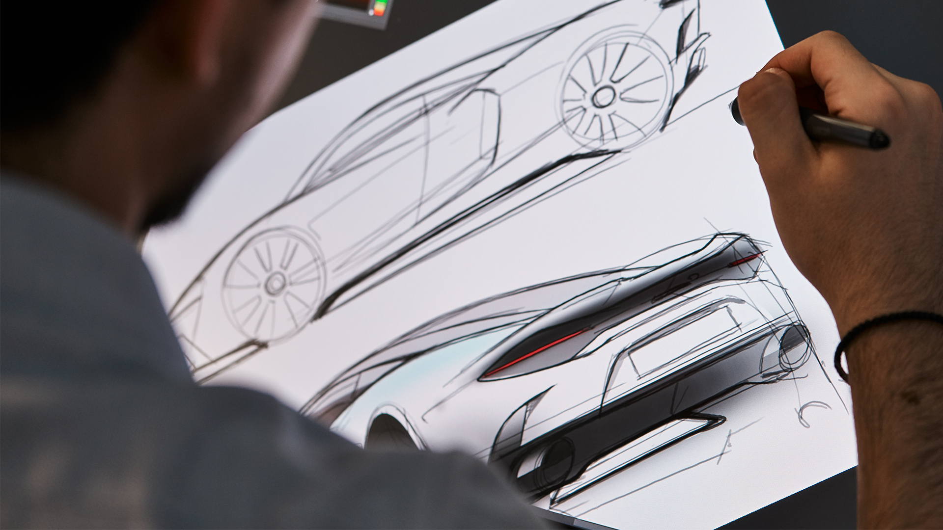 Over the shoulder of a designer or engineer sketching a McLaren car.