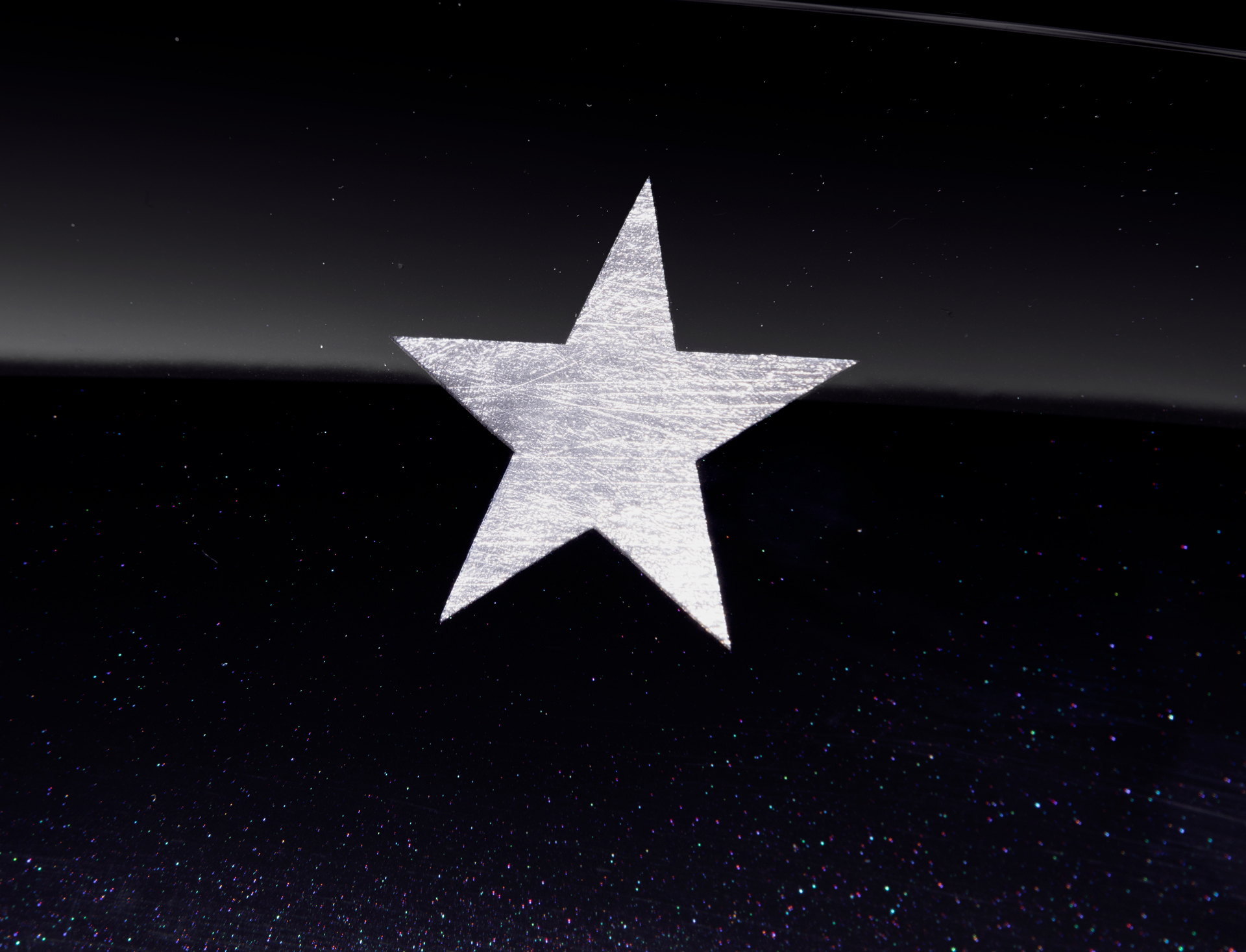 Detailed close-up of a silver star graphic on the black paintwork of the MSO Project Viva 750S, representing one of the ten McLaren Constructors' World Championships.