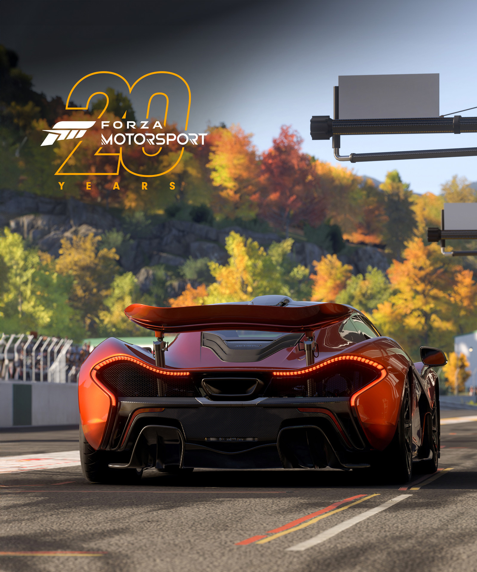 Burnt orange McLaren P1 waiting at a race track starting line, surround by autumn trees. A "Forza Motorsport 20 Years" logo is superimposed on the top left side of the image.