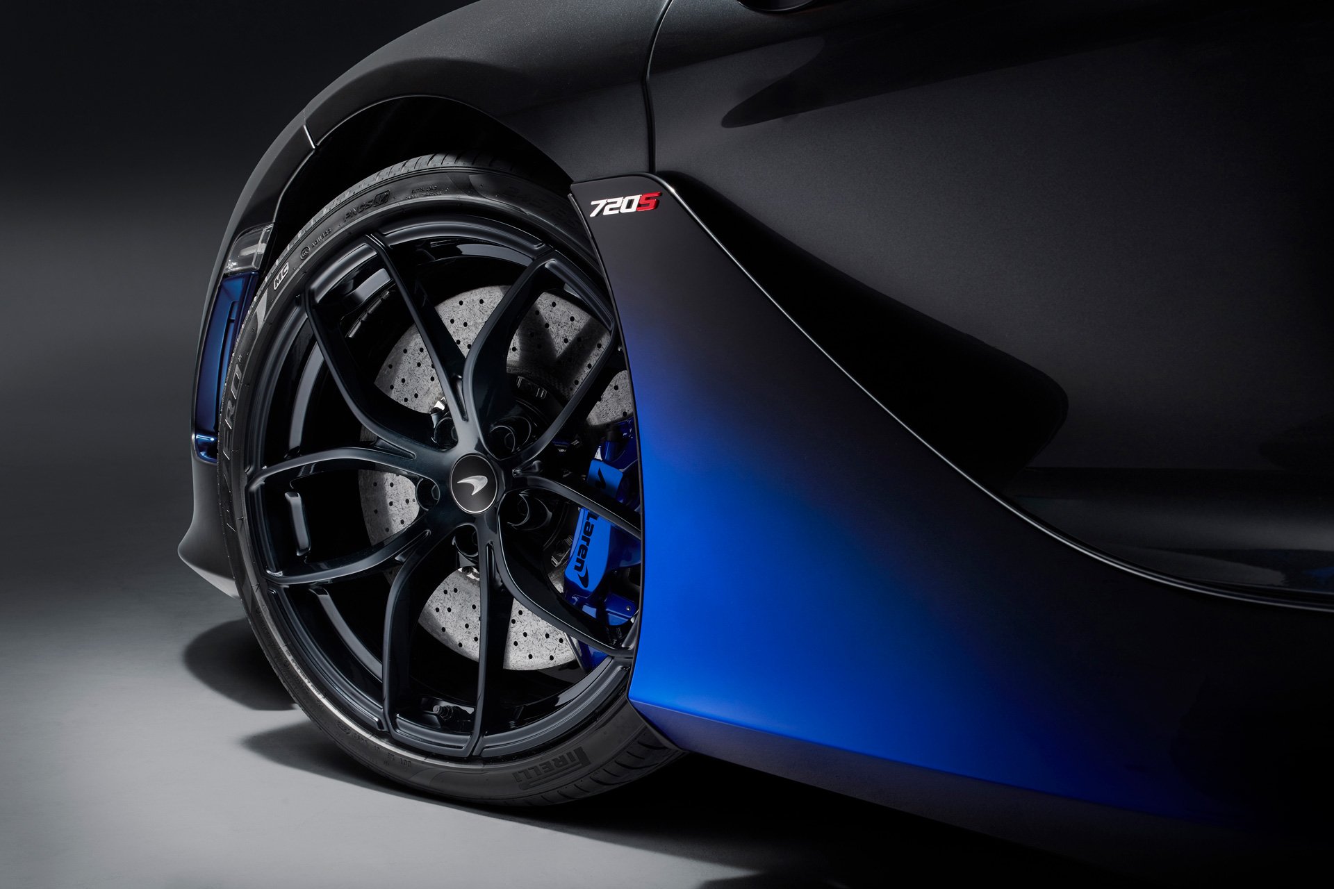 Close up of a McLaren 720S side and wheel, showcasing bespoke blue spray paint. 